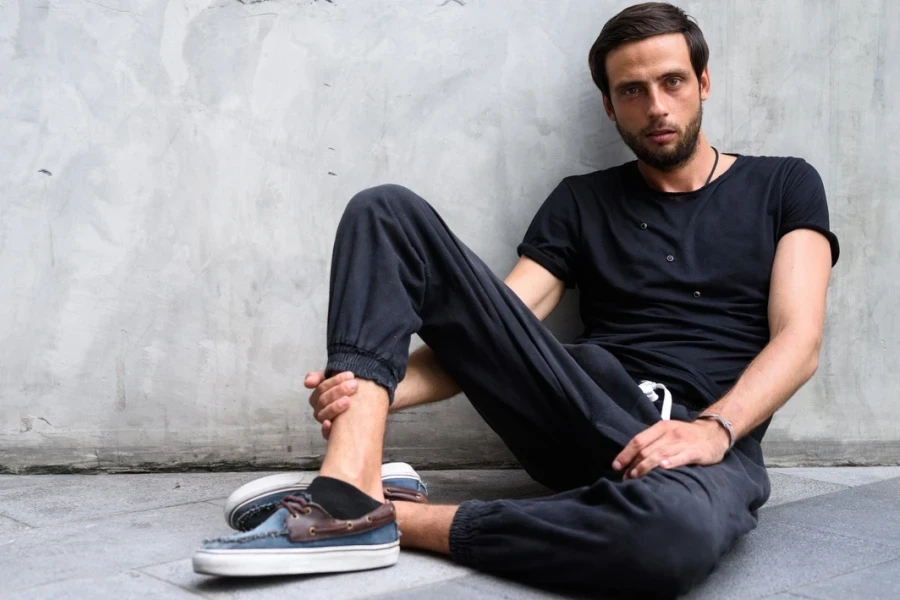 Handsome man wearing drawstring pants and deck shoes.