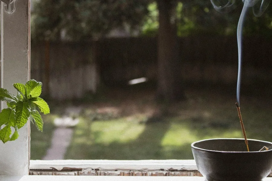 Des bâtons d'encens brûlent sur le joint de la fenêtre