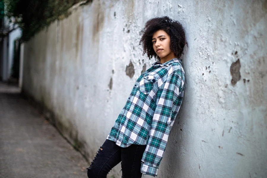Lady with an oversized flannel shirt and ripped skinny jeans