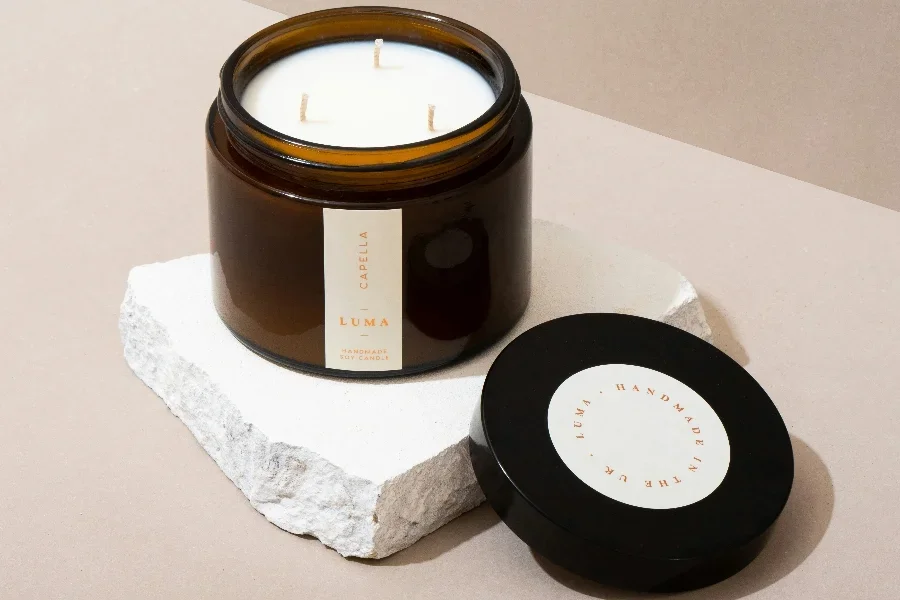 Vela grande de cera de soja blanca sobre un trozo de mármol.