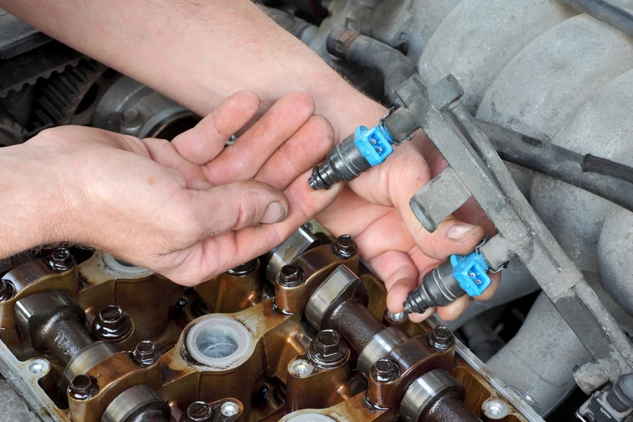 Man holding up fuel injectors