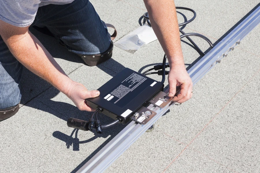 Man installing a microinverter for solar panels