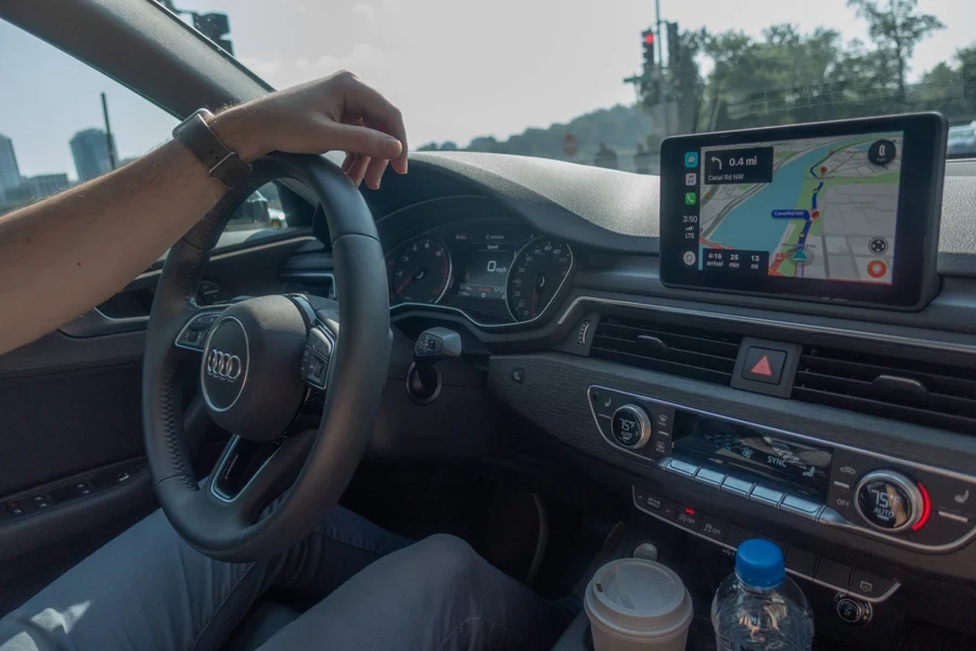 Man using a CarPlay screen on an older vehicle