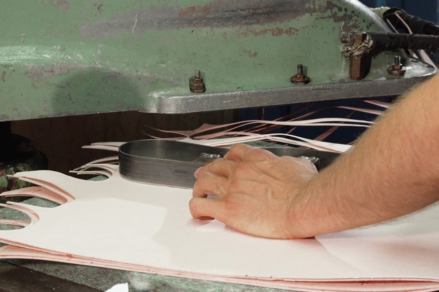 Man using a die-cutter on some fabric