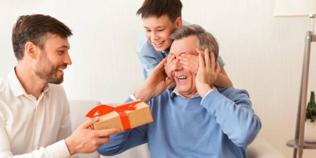 Mature son and grandson gifting granddad a present