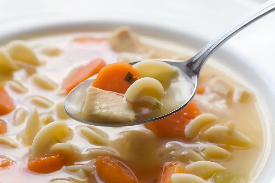 Metal spoon with vegetable soup