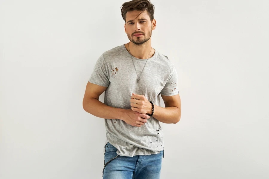 Model wearing a distressed T-shirt and faded skinny jeans
