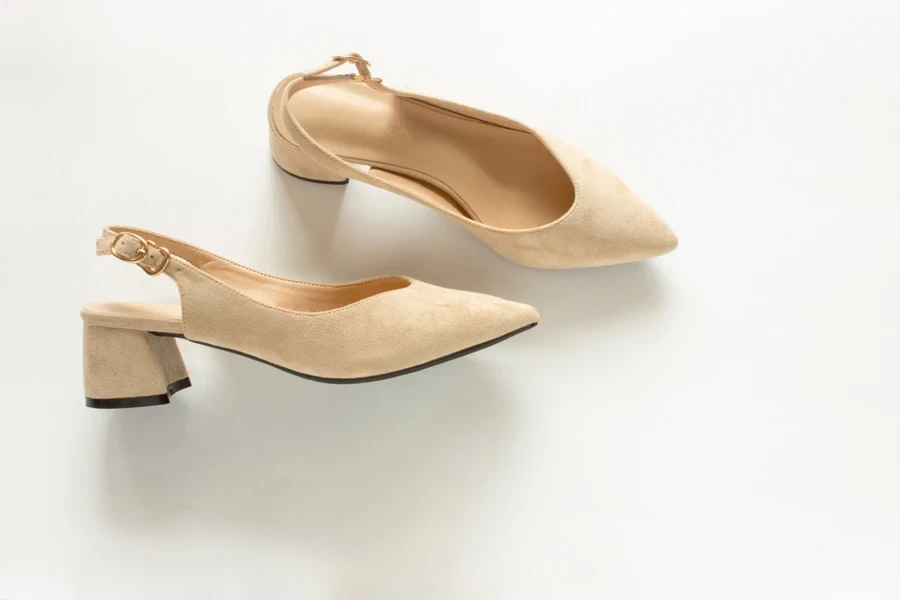 Nude-colored Slingback mules against a white background