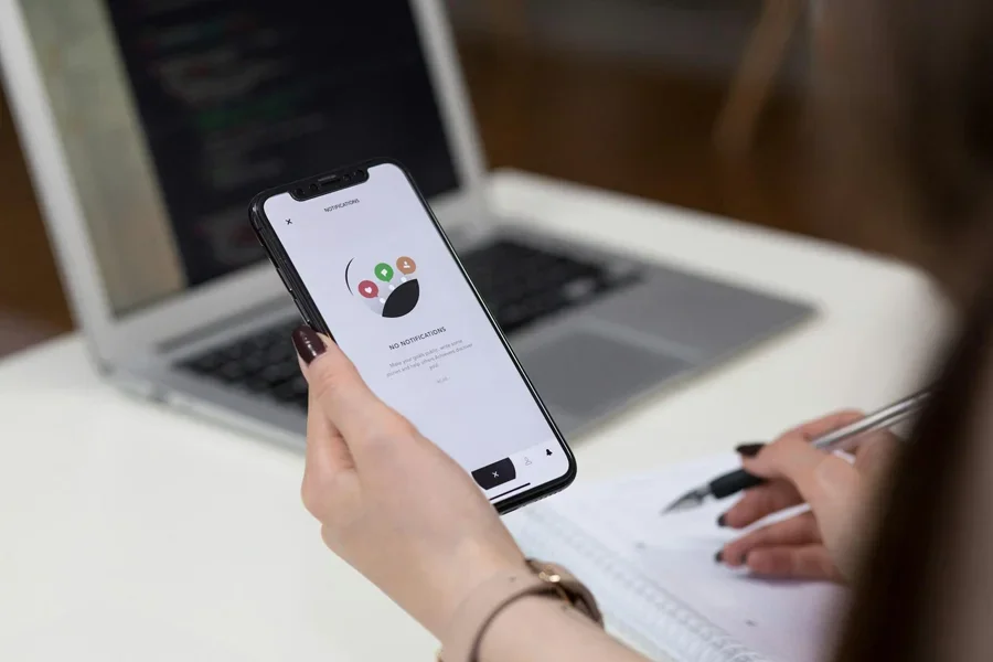 Person holding iPhone while writing