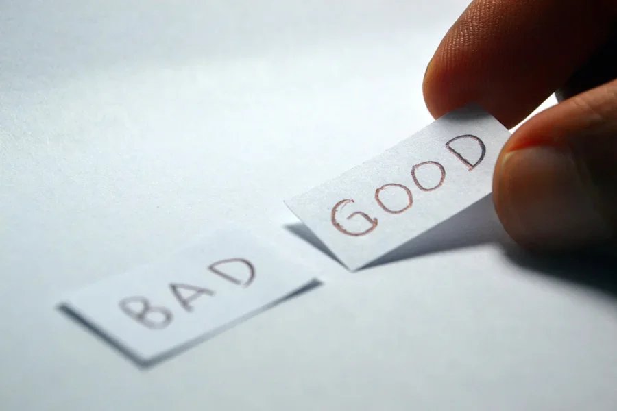 Person holding papers with the words BAD and GOOD