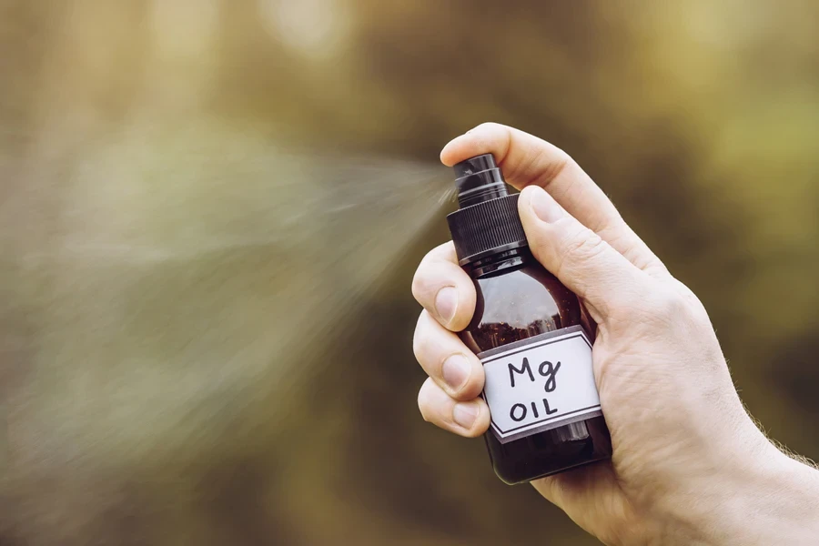 Person spraying scalp spray into the air outside