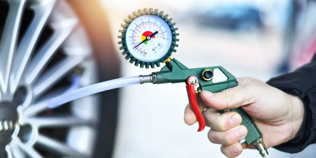 Person using tire inflator with pressure gauge