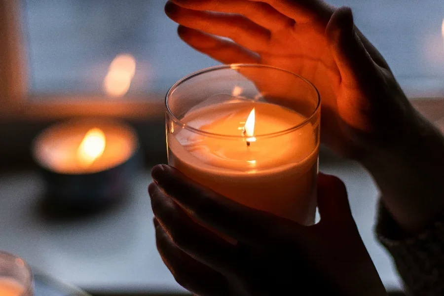 Persona con una vela de soja en sus manos.