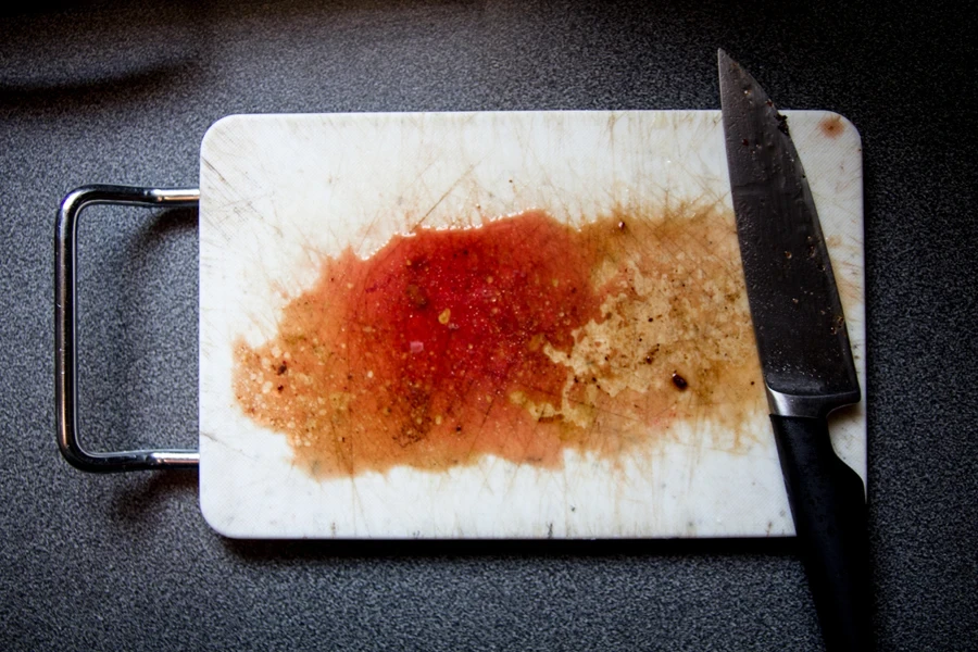 Plastic chopping board with metal handle on the side
