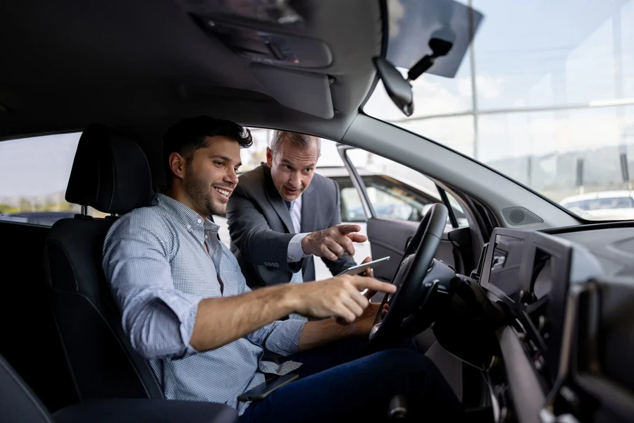 Salesman showing prospective customer the car player