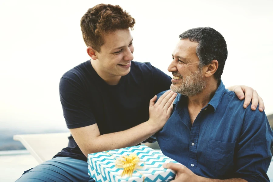 Son presenting gift to happy father