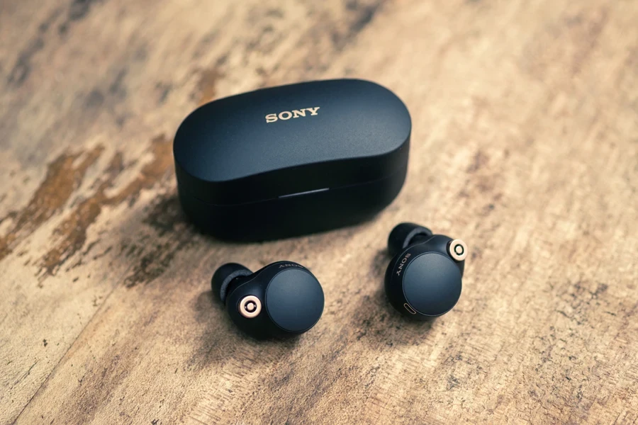 Sony earbuds on a table beside the case
