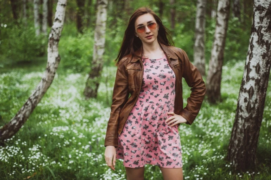 Stylish woman wearing a brown leather jacket and pastel dress