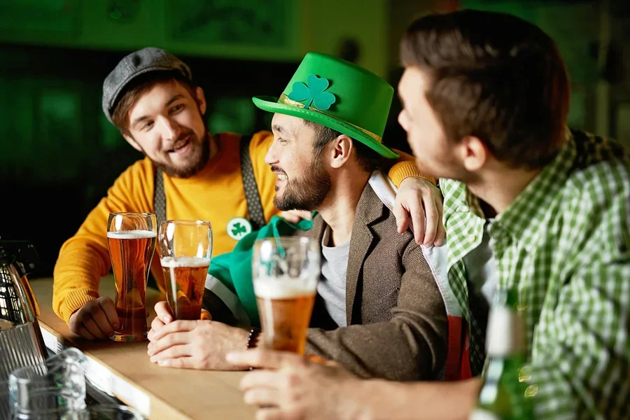 Tiga teman menikmati perayaan Hari St. Patrick di sebuah pub sambil menikmati minuman
