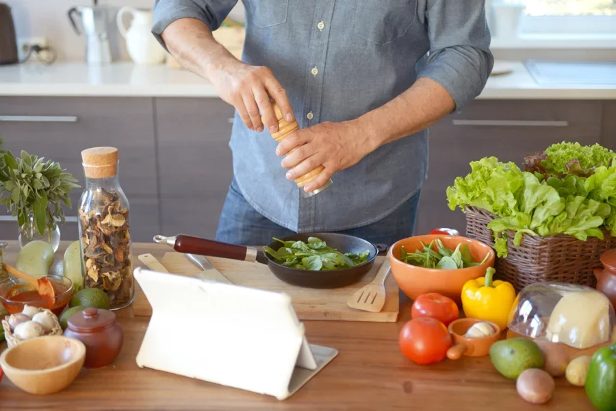 Twisting HexMill salt grinder over salad greens during the day