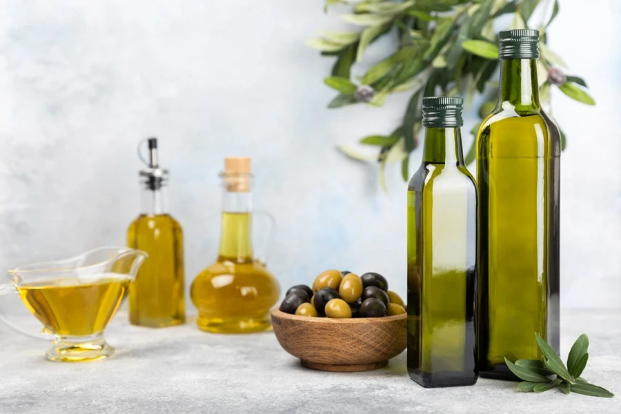 Two nice size dark green olive oil bottles with olives