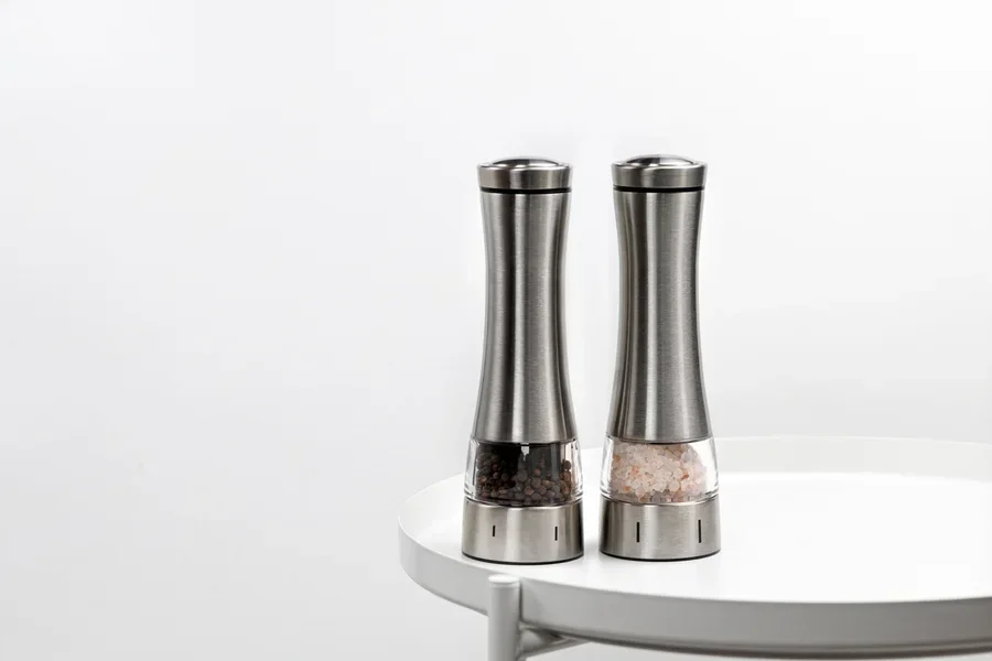 Two stainless steel grinders with coarse grinds inside
