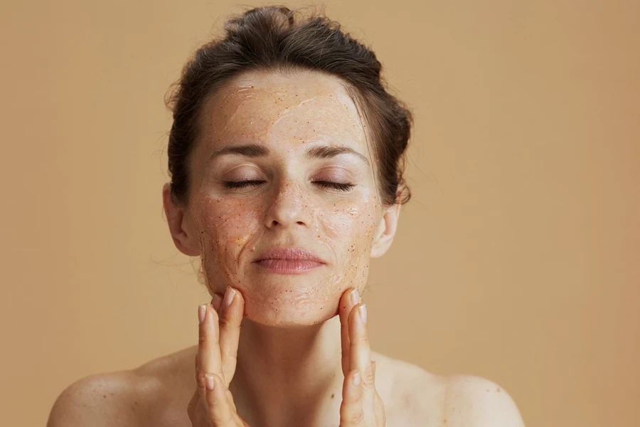 Woman applying exfoliating product to remove dead skin cells