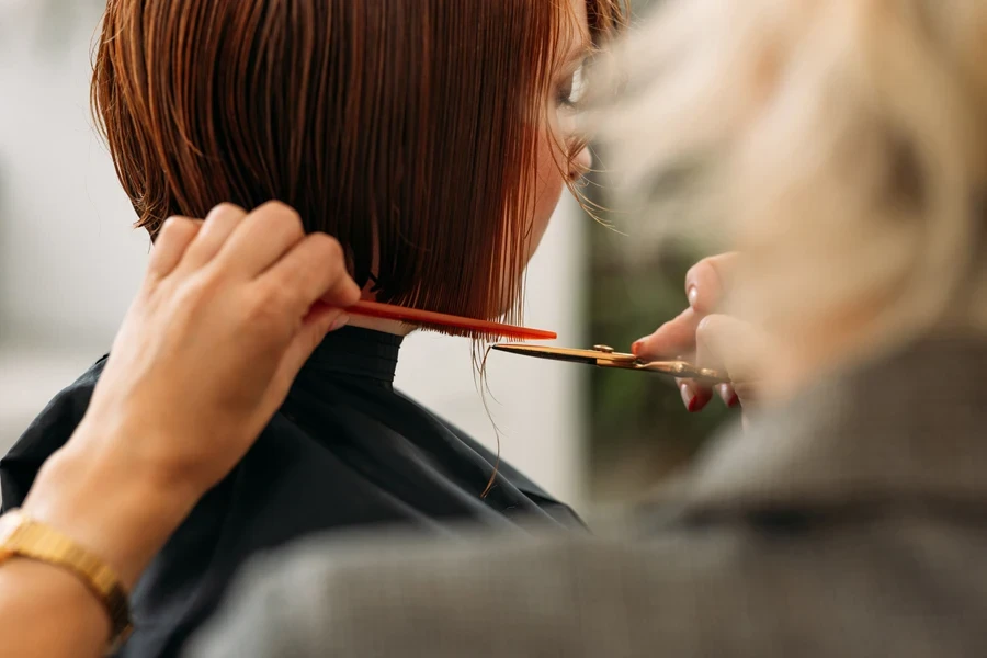 Woman at hairdressers getting hair cut in shorter style