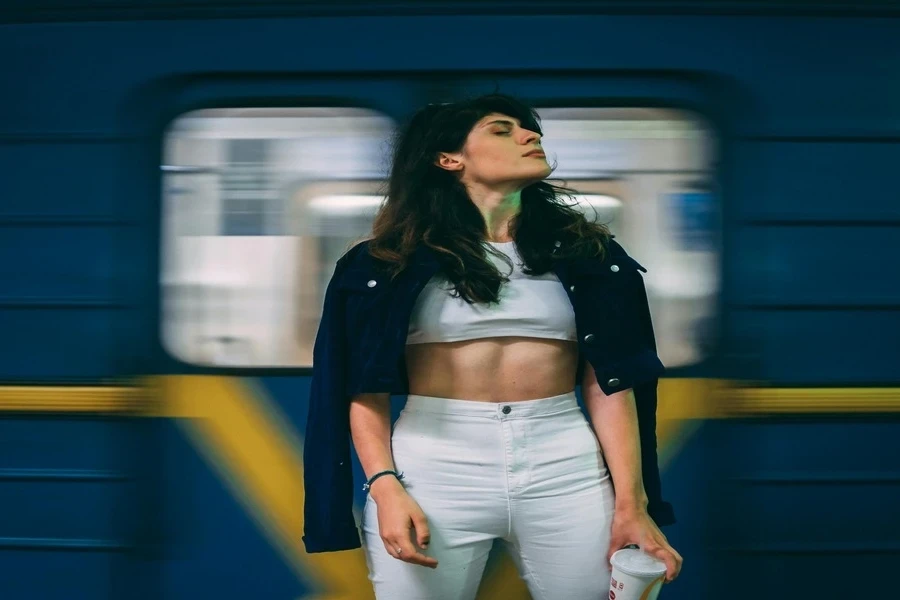 Woman in a cropped jacket posing in subway station