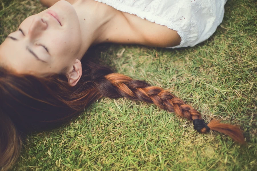 Woman sleeping on grass with Dutch braid in place