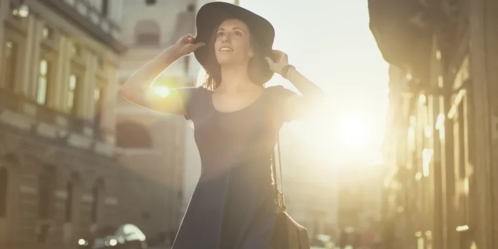 Woman walking down street wearing black solar panel hat