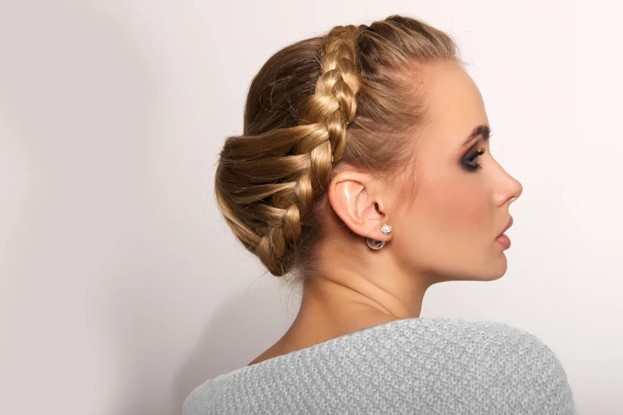 Woman with dark blond hair wearing updo of Dutch braids