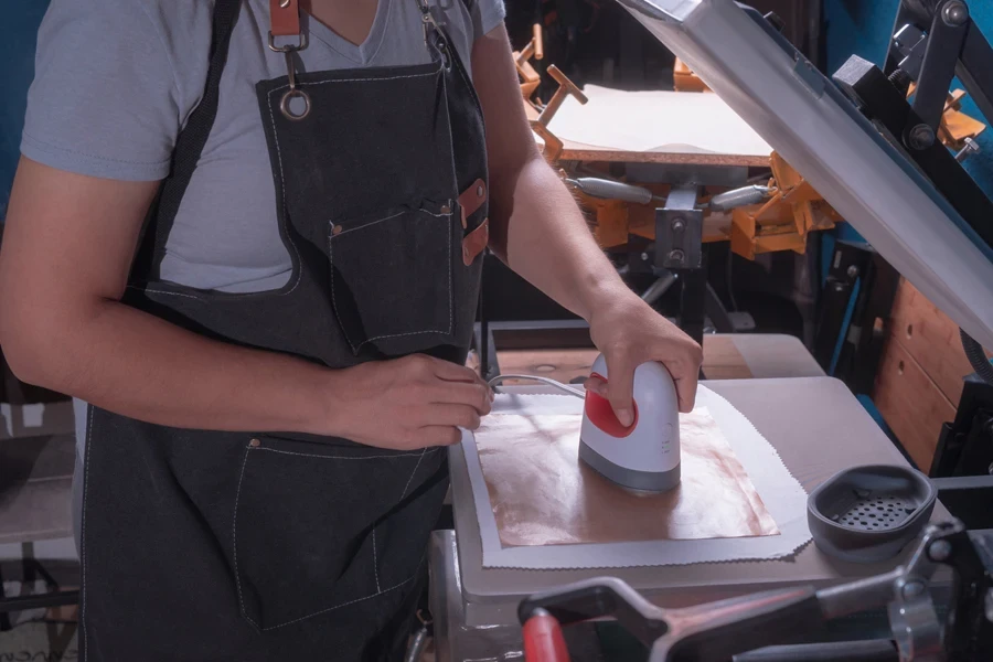 Woman working on a design with a mini versatile heat press