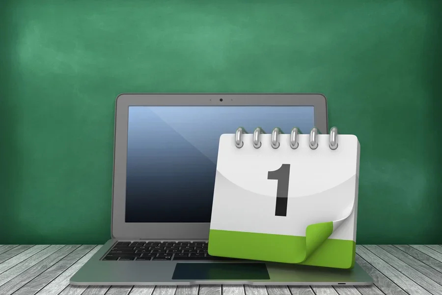 3D rendering of laptop and calendar on chalkboard background