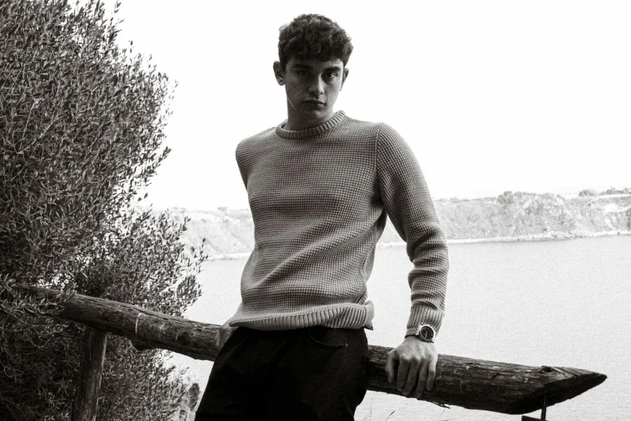 A Man in Sweater Leaning on a Railin