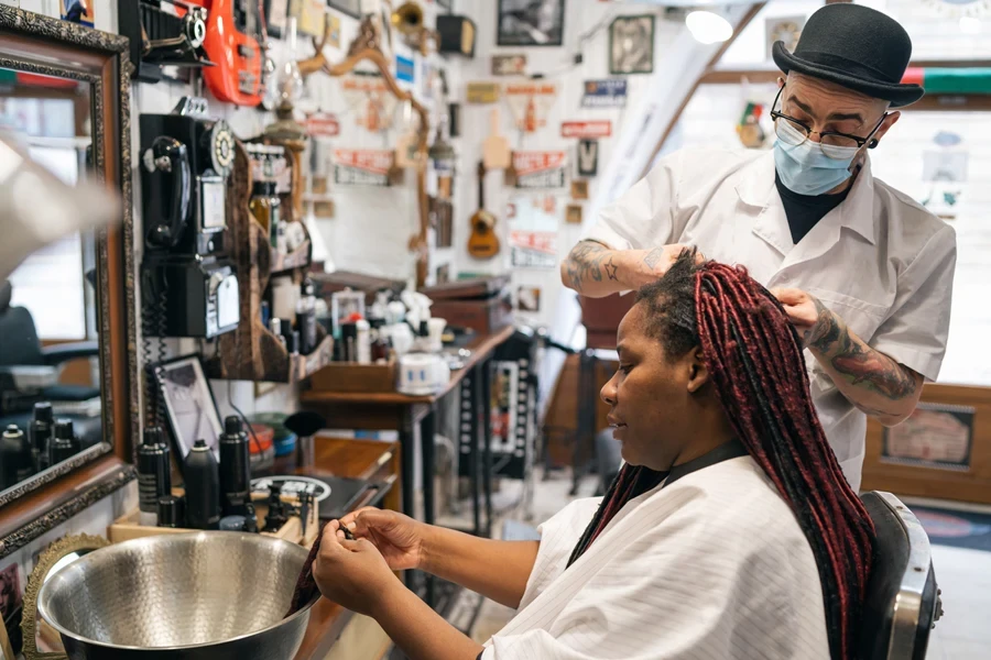 A hairdresser fixing wicks locs