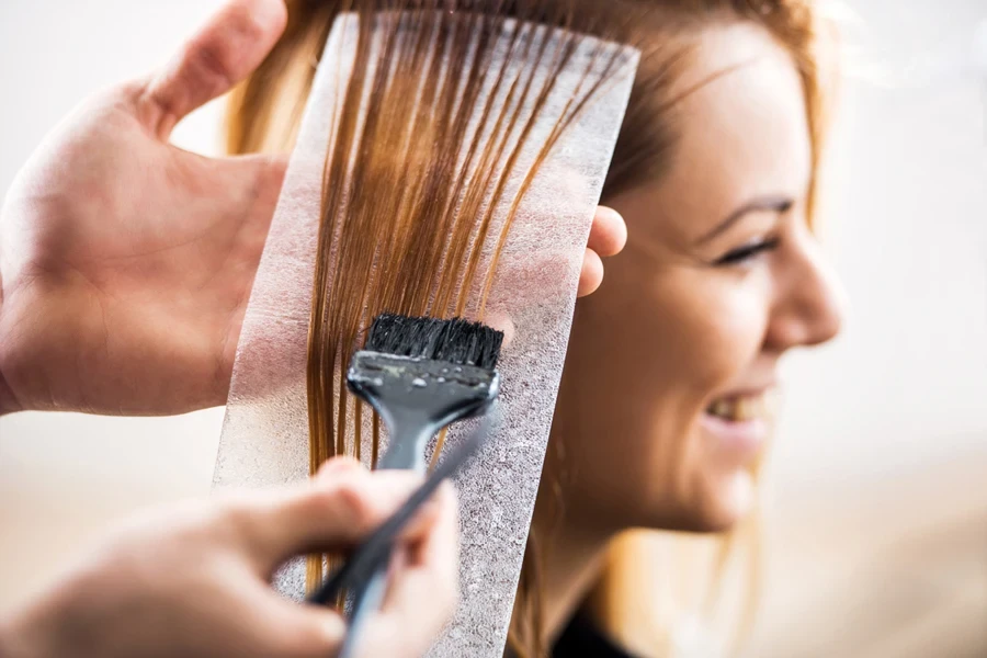 A hairstylist giving a client highlights