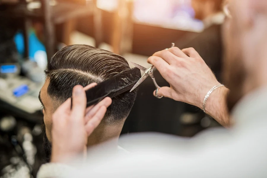 A hairstylist styling a pompadour haircut