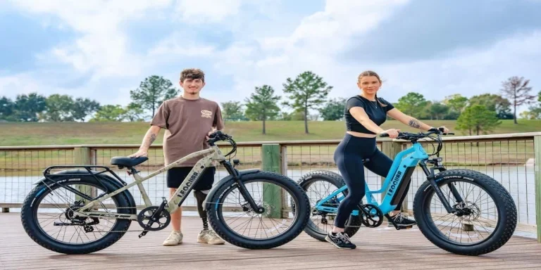 A man and a woman standing next to their e-bikes