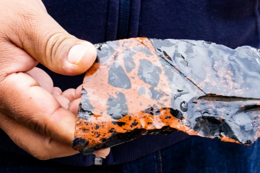 Un hombre sosteniendo una piedra de obsidiana de caoba.