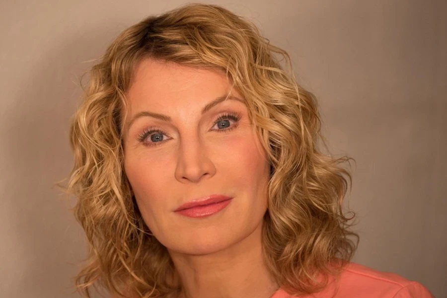 A middle-aged woman with blond and curly hair