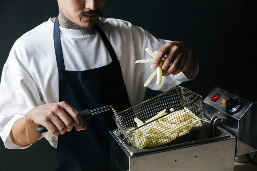 A person cooking french fries