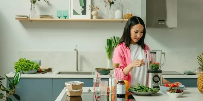 A person in a kitchen making a salad