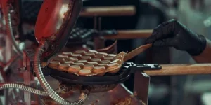 A person making waffles in a waffle iron