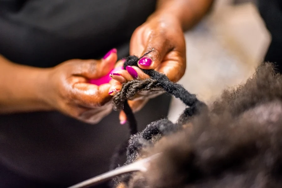 A person using a hook on locs
