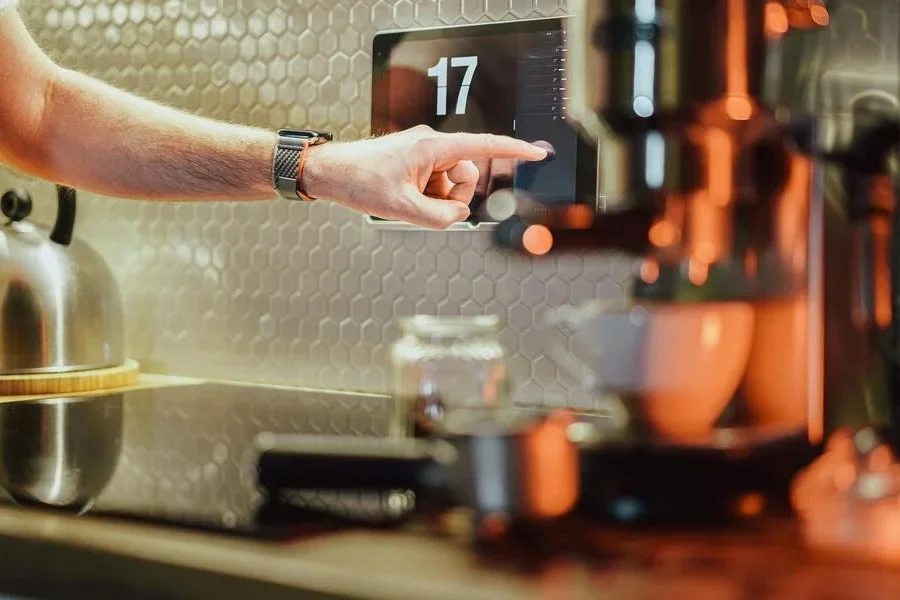 A person using the touchscreen on a coffee machine