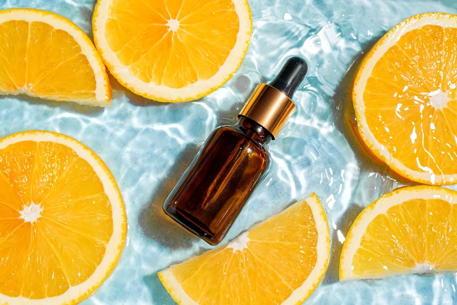 A serum bottle and oranges in water