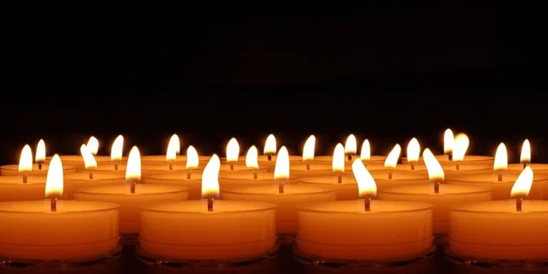 A set of lit tea light candles on surface