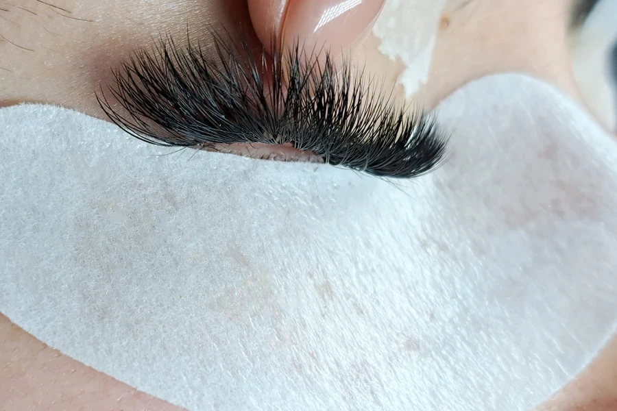 A stylist installing a lash cluster