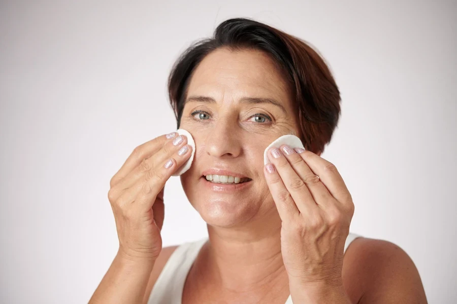 A woman applying beauty product on her face